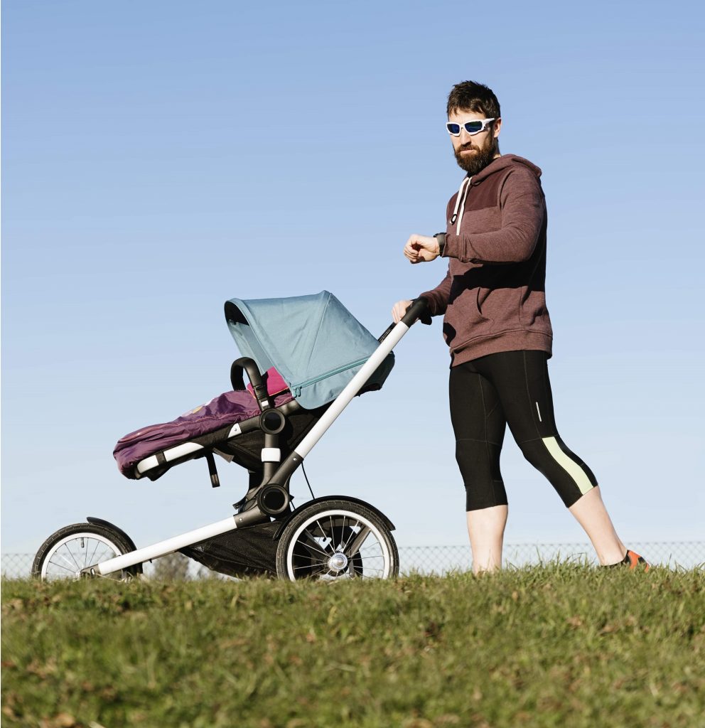 Father is jogging with his baby in the stroller